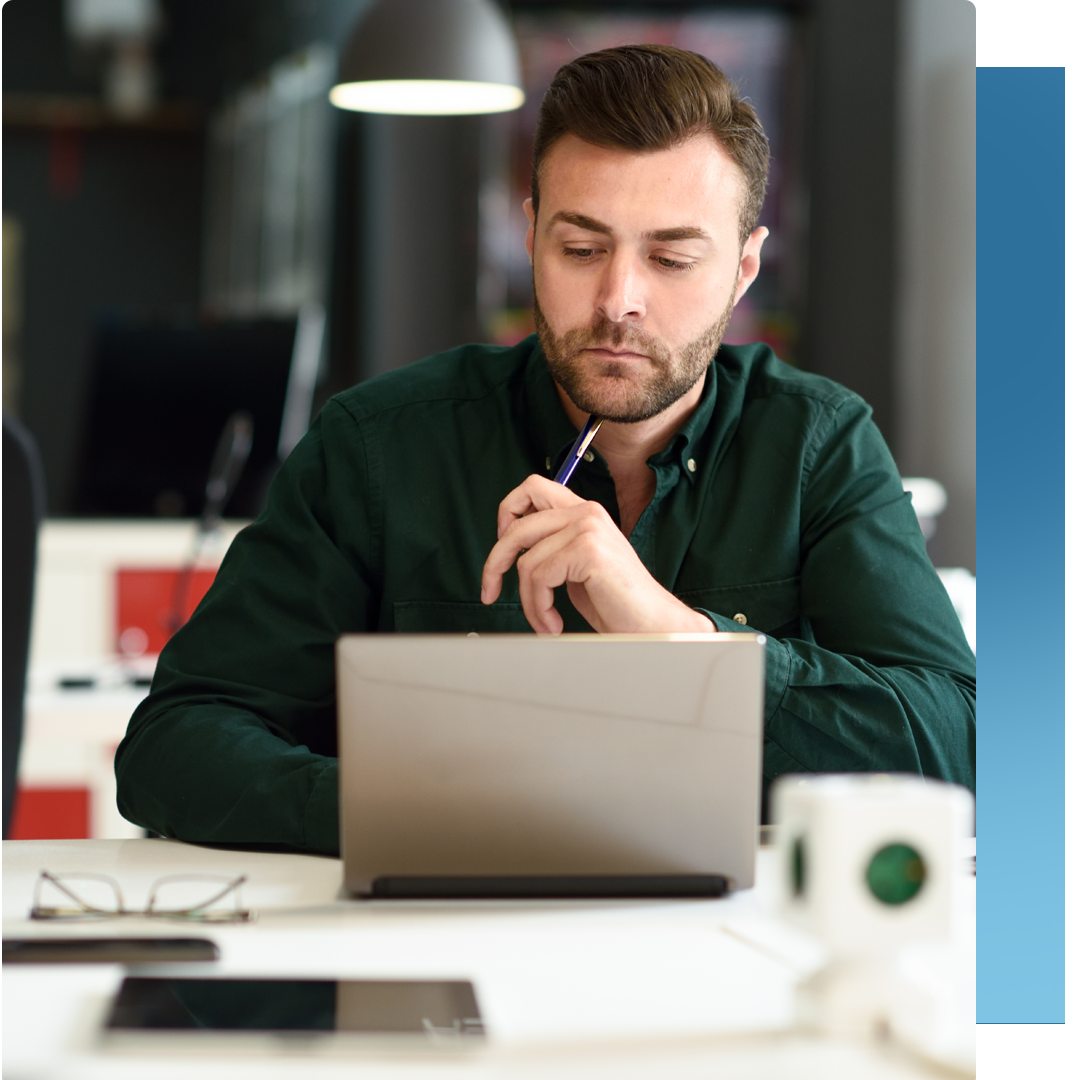 person pondering information at desk/laptop