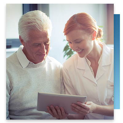 An assistant and elderly man looking at a tablet together
