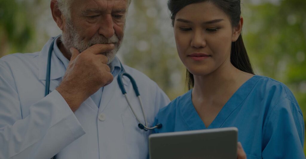 doctor and nurse looking at laptop