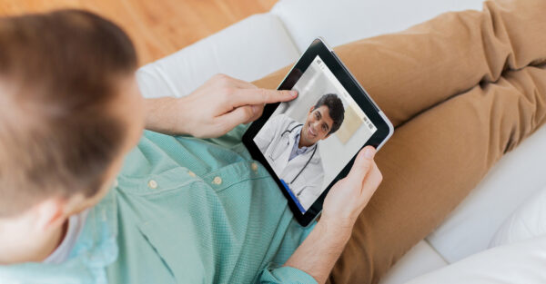 A young man speaking with a doctor on a video call on his tablet