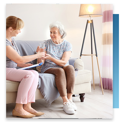 An elderly woman sitting on the couch in her colorfully decorated room