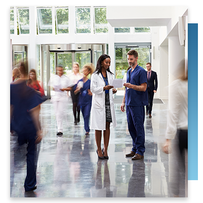Hospital staff talking in a busy hallway