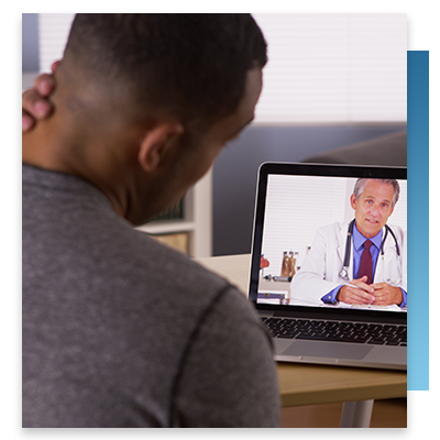 A young man holding his neck while speaking with a doctor on a telehealth call