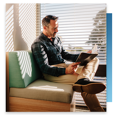 A man sitting on a comfortable bench in a hospital room