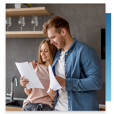 A young couple looking at a billing statement happily