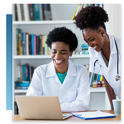 Two nurses talking while looking at a laptop