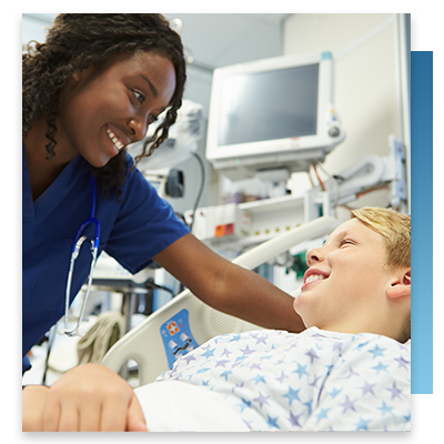 A nurse leaning over a young patient in a hospital bed