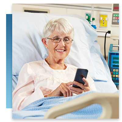 An older woman on her phone while resting in a hospital bed