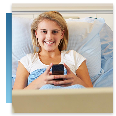 A young girl in a hospital bed on her phone