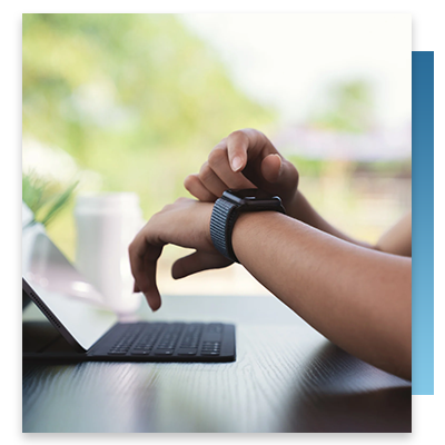 A person touching their smartwatch at their desk
