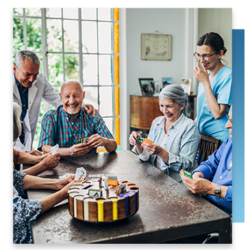 A group of seniors with a doctor and nurse playing a card game