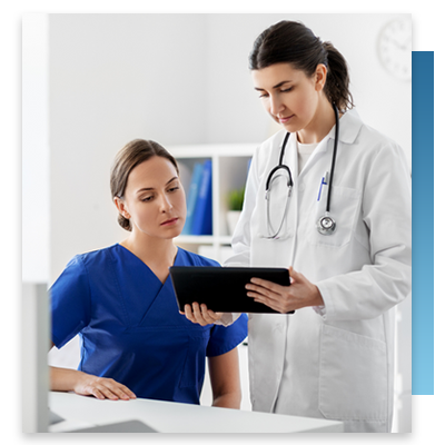 A nurse and doctor looking at a tablet at a work station