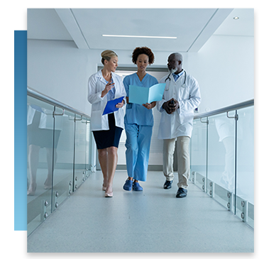A nurse and two doctors walking together through a healthcare facility