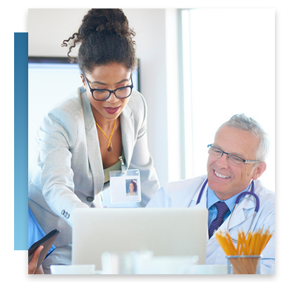 A hospital administrator and doctor looking at a computer during a meeting