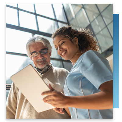 An older patient on a tablet with the help of a nurse