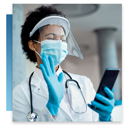A doctor in a face mask and shield on a video chat on their phone