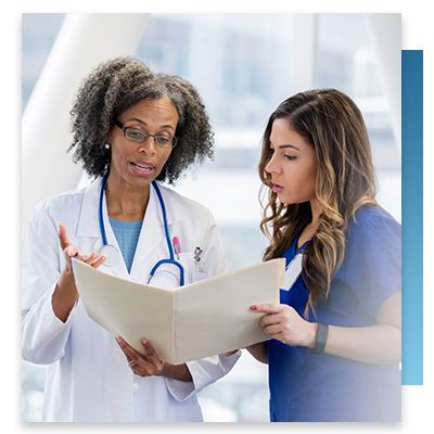 A doctor and nurse talking while looking at a patient file