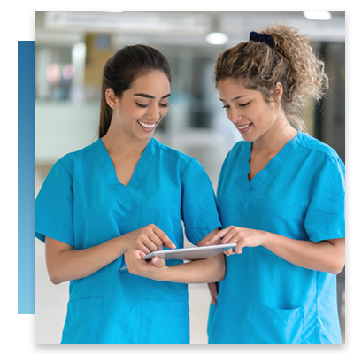 Two nurses looking at  a tablet while talking