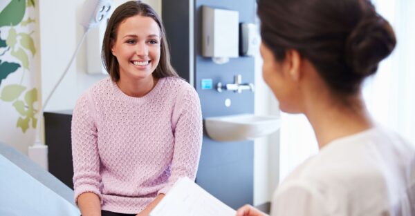 A nurse talking with a smiling patient