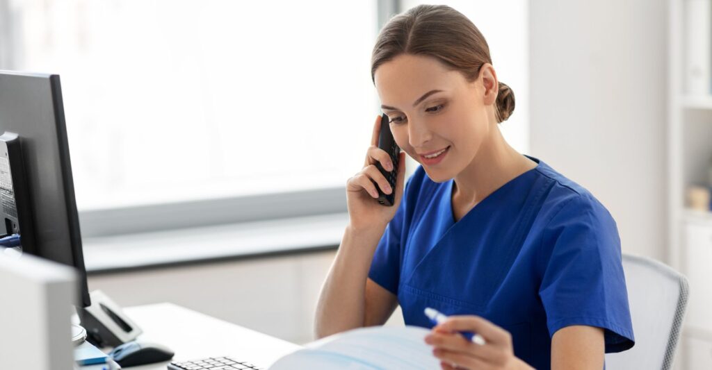 A nurse on a wireless phone at her desk