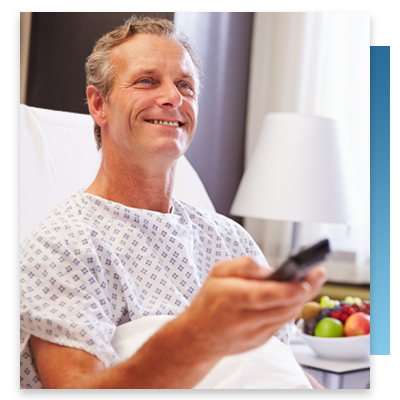 A patient in a hospital bed using a remote