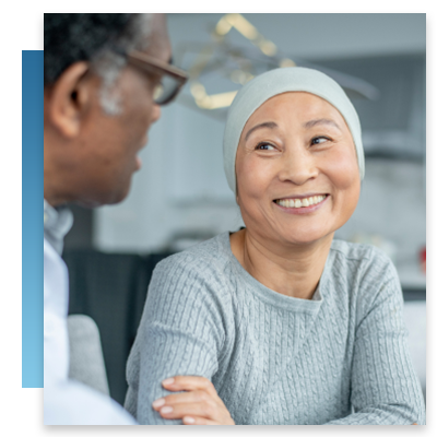 An Asian patient smiling while speaking to her doctor
