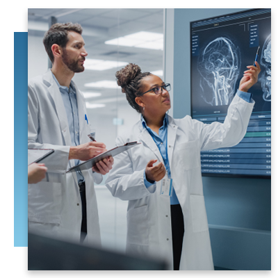 Two doctors looking at a screen with brain scans