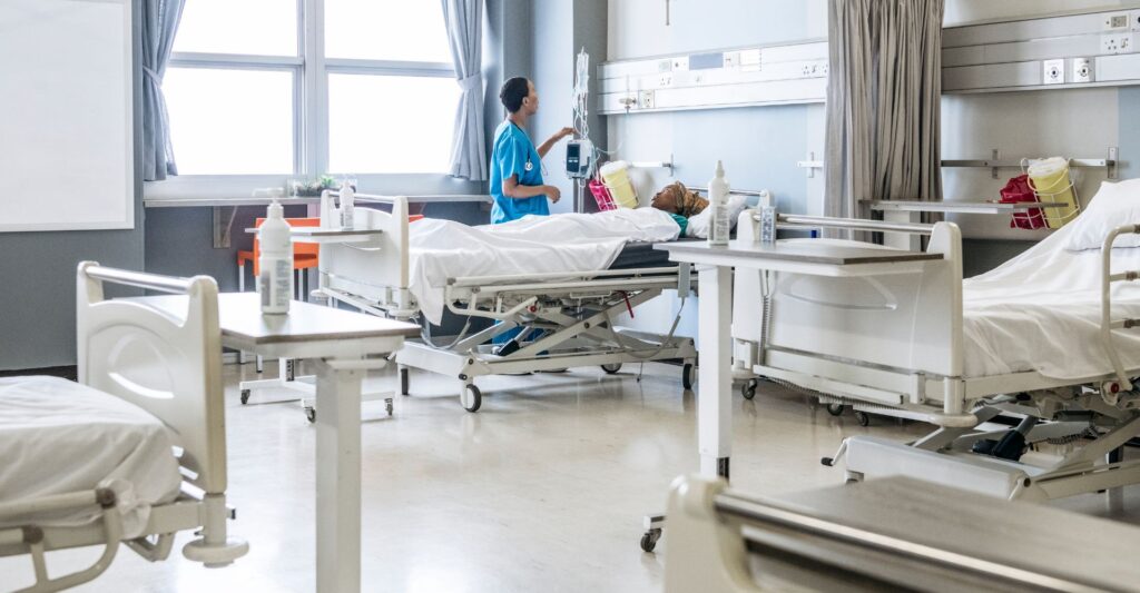 A nurse checking on a patient in their hospital room