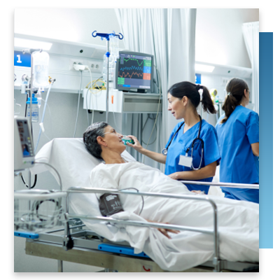 A nurse checking on a patient in their hospital bed