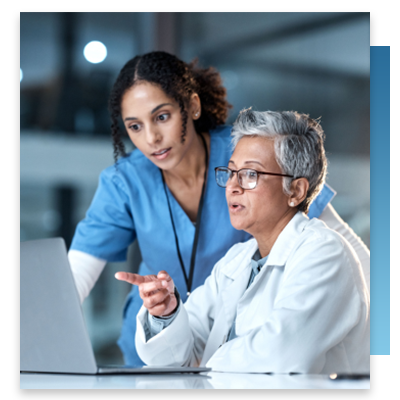 A doctor and nurse having a conversation while looking at a computer