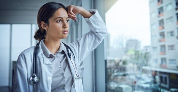 A tired doctor looking out of a window