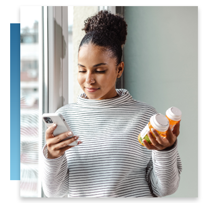 Woman with phone in one hand and prescriptions in the other